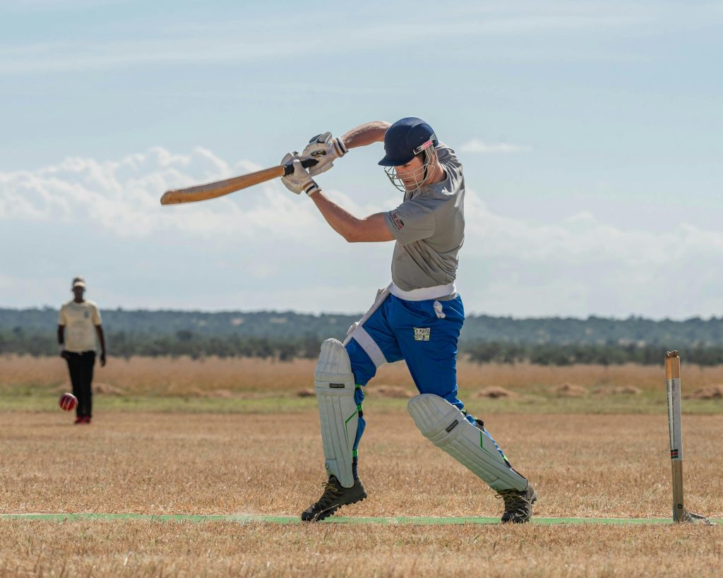 Dynamic cricket scene with a batsman playing confidently on a clear day.