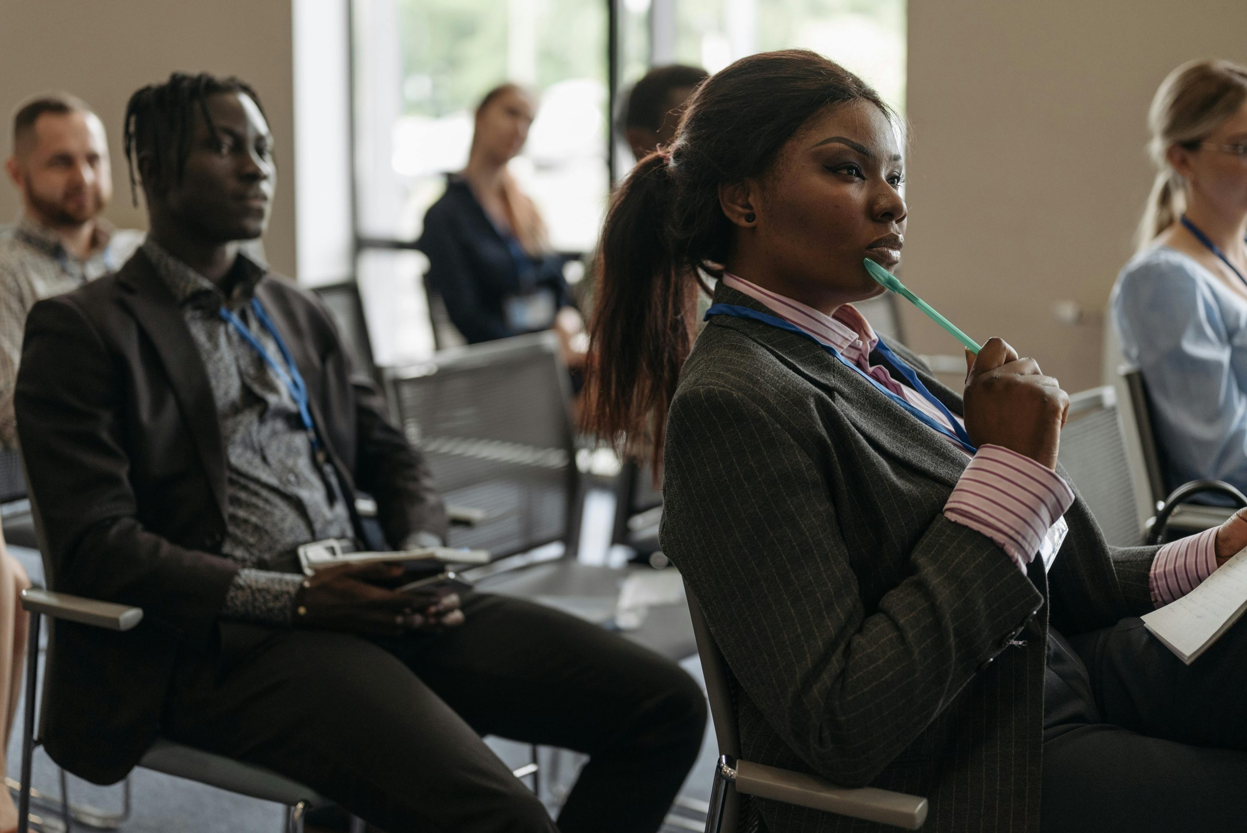 Diverse group of professionals attentively listening in a business conference setting.
